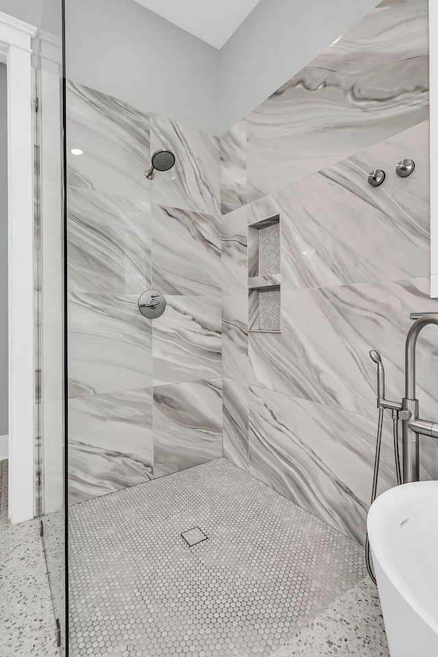 bathroom featuring a marble finish shower and a soaking tub