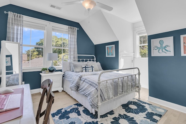 bedroom with vaulted ceiling, light wood-style flooring, baseboards, and a ceiling fan