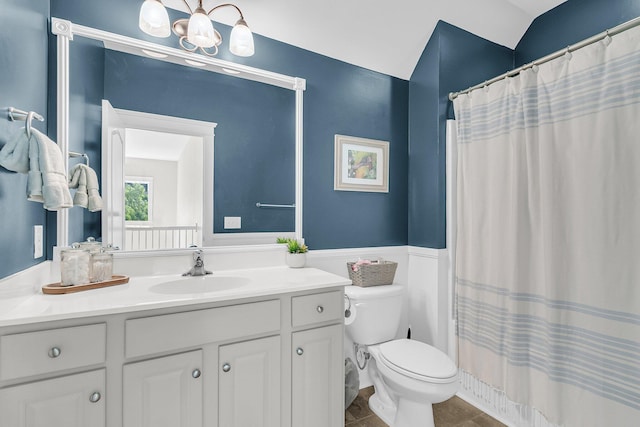 bathroom featuring vanity, toilet, a wainscoted wall, a chandelier, and curtained shower