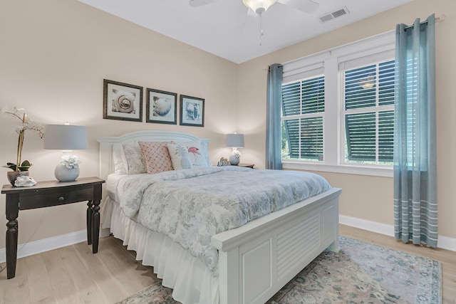 bedroom featuring light wood finished floors, baseboards, and a ceiling fan
