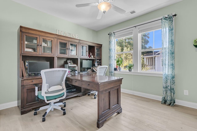 office featuring light wood-style flooring, a ceiling fan, and baseboards