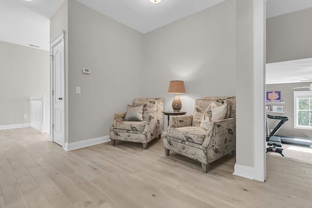sitting room featuring light wood finished floors, baseboards, and baseboard heating