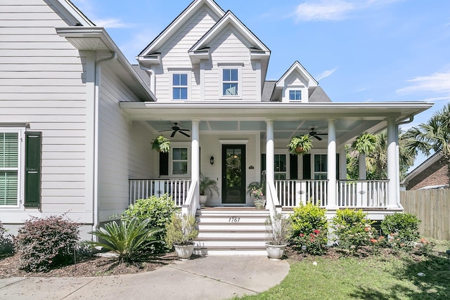 entrance to property with a ceiling fan, a porch, and fence