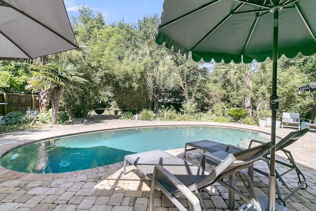 swimming pool featuring a patio and fence
