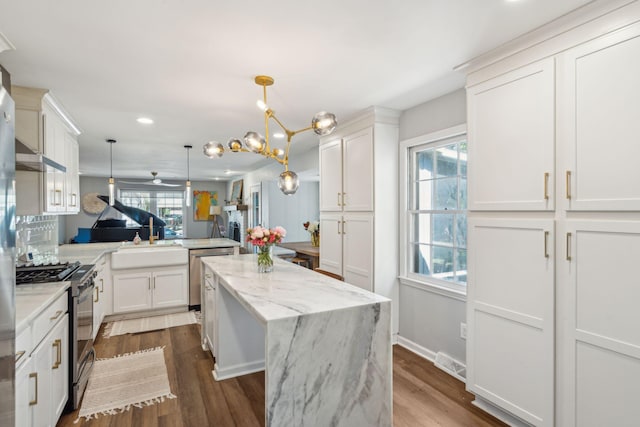 kitchen with kitchen peninsula, appliances with stainless steel finishes, a healthy amount of sunlight, and sink