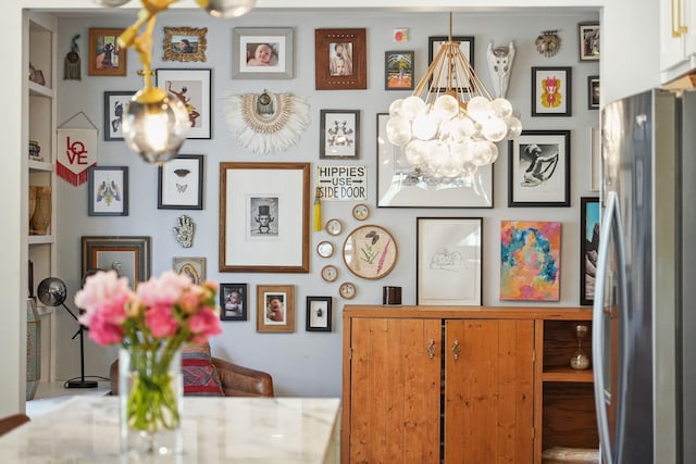 room details featuring a notable chandelier and stainless steel fridge