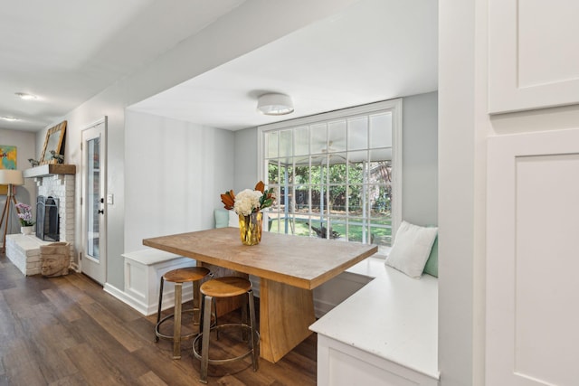 dining area featuring a fireplace and dark hardwood / wood-style flooring