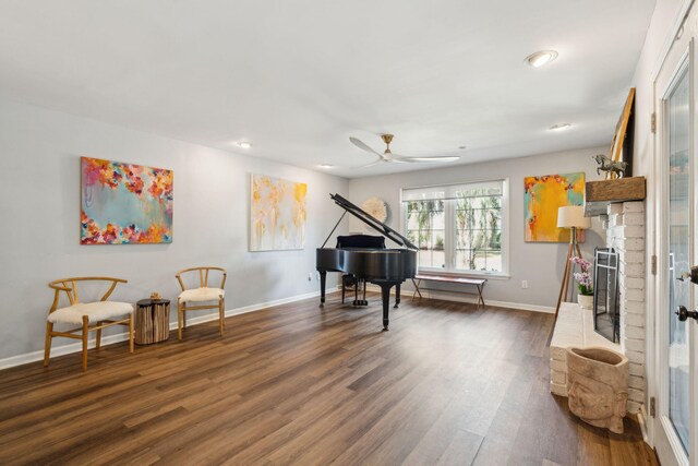 interior space featuring dark wood-type flooring, a fireplace, and ceiling fan