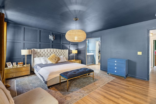 bedroom featuring ensuite bathroom and wood-type flooring