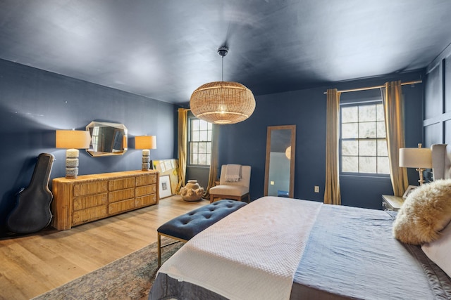 bedroom with hardwood / wood-style flooring and multiple windows