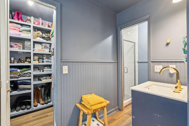 bathroom featuring vanity, hardwood / wood-style flooring, and a shower with door