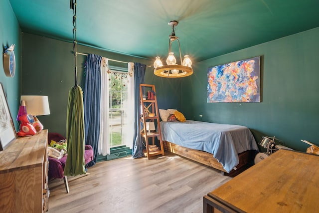 bedroom featuring light hardwood / wood-style floors and a notable chandelier