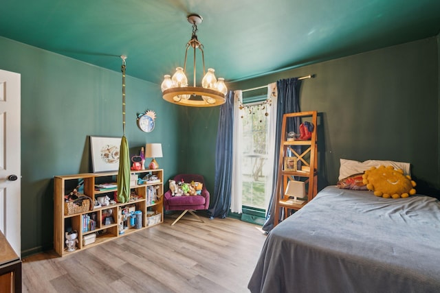 bedroom with light wood-type flooring and a notable chandelier