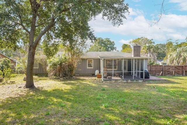 back of house with a sunroom and a yard