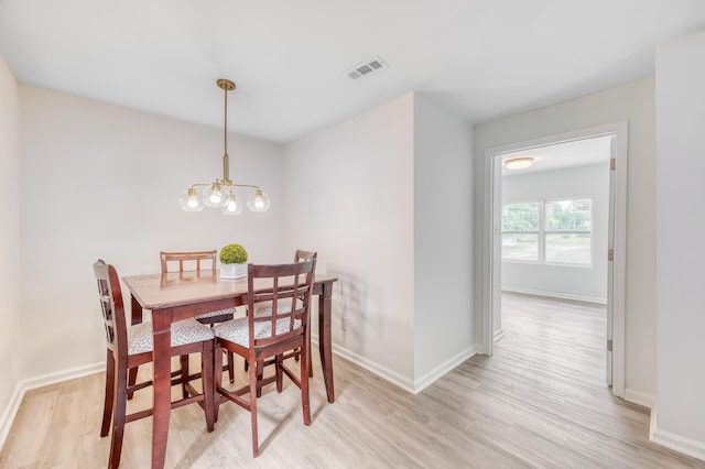 dining room with light wood-type flooring and a notable chandelier