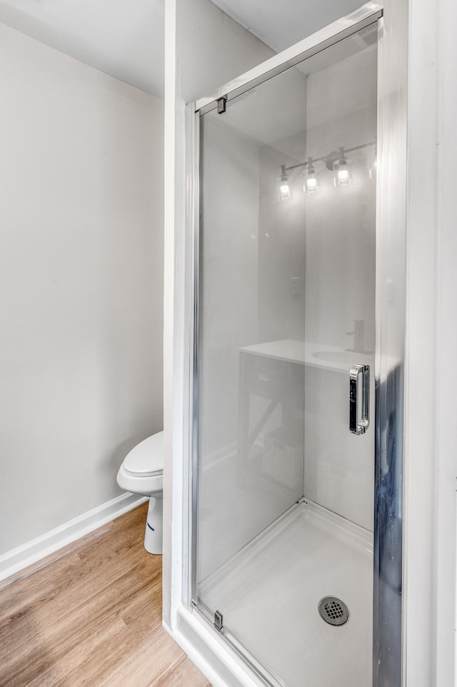 bathroom featuring toilet, hardwood / wood-style floors, and walk in shower