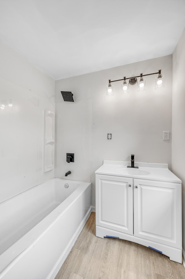 bathroom featuring vanity, hardwood / wood-style flooring, and bathing tub / shower combination