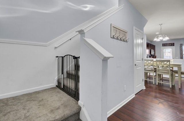 stairway with a notable chandelier