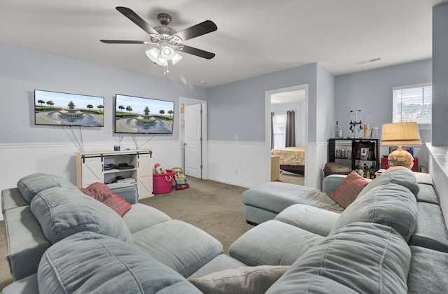 carpeted living room with ceiling fan