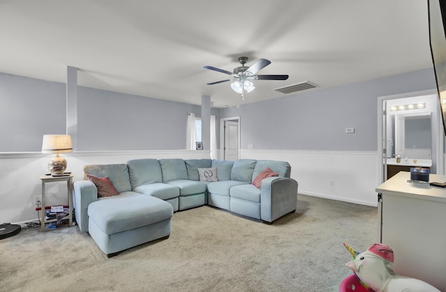 carpeted living room with ceiling fan