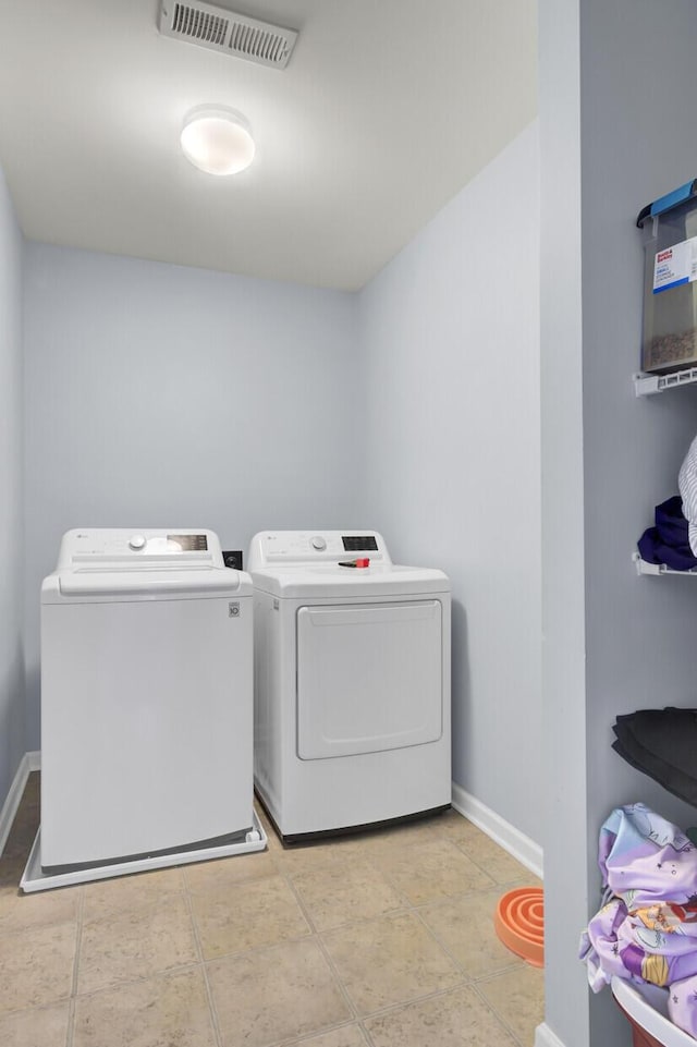 washroom featuring light tile patterned floors and washer and clothes dryer