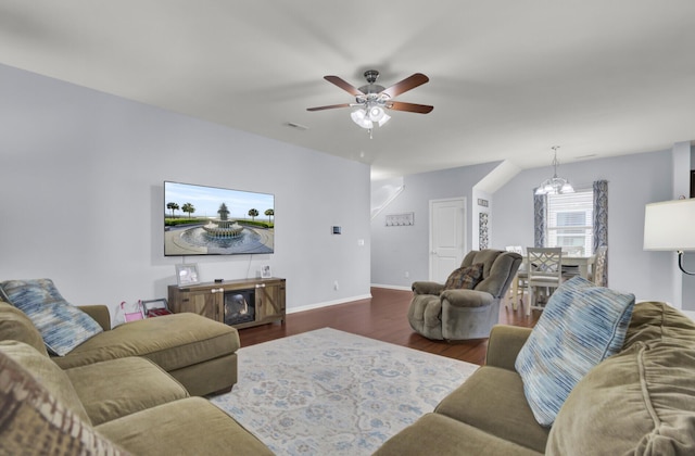 living room with dark hardwood / wood-style floors and ceiling fan with notable chandelier