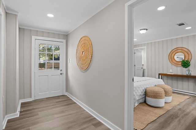 entryway with ornamental molding and light hardwood / wood-style flooring