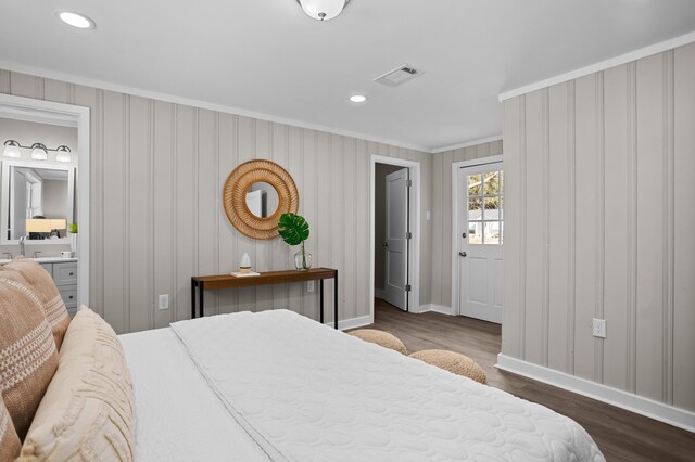 bedroom with crown molding, ensuite bathroom, and dark hardwood / wood-style floors