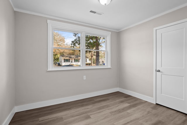 empty room featuring ornamental molding and light hardwood / wood-style floors