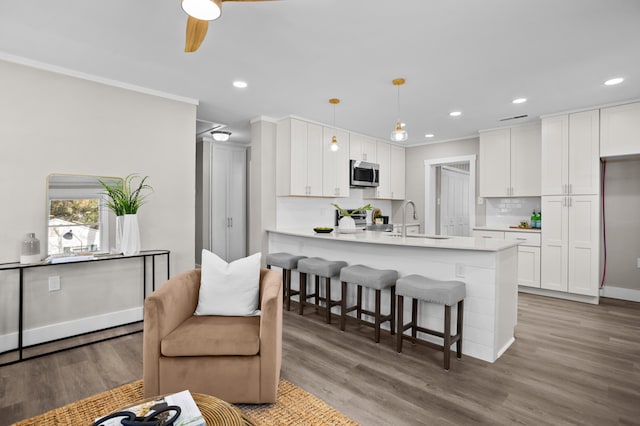 kitchen featuring appliances with stainless steel finishes, sink, pendant lighting, and white cabinets