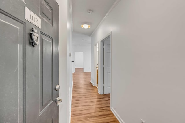 corridor with hardwood / wood-style floors and crown molding