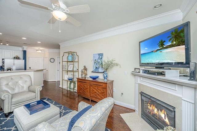 living room featuring ornamental molding, a premium fireplace, wood finished floors, and baseboards