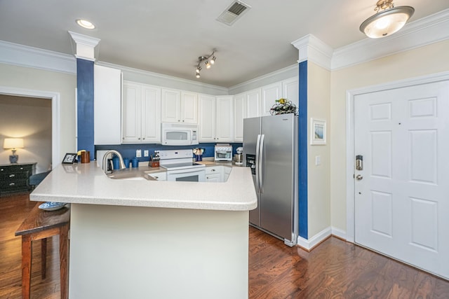 kitchen with ornamental molding, white appliances, visible vents, and a peninsula