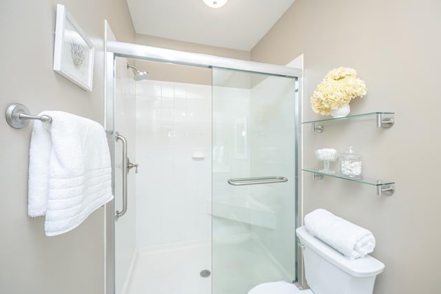 bathroom featuring a shower stall and toilet