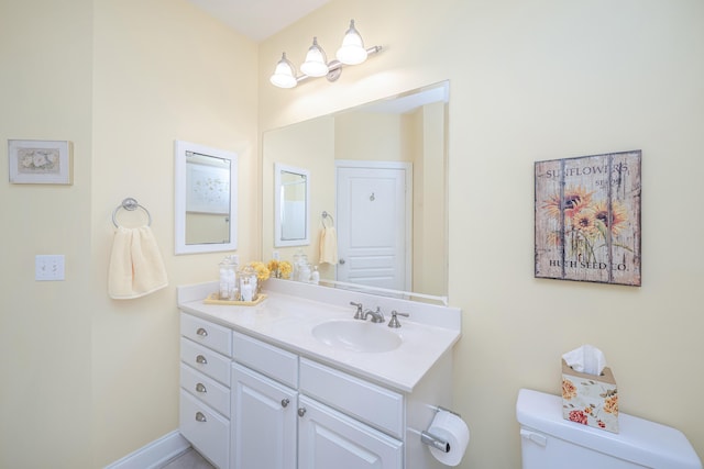 half bath featuring toilet, baseboards, and vanity