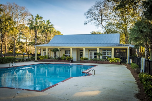 community pool with fence and a patio