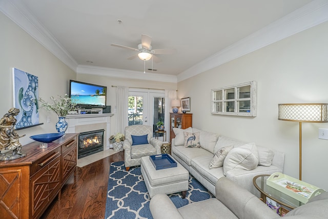 living room featuring a fireplace with flush hearth, dark wood finished floors, a ceiling fan, and crown molding