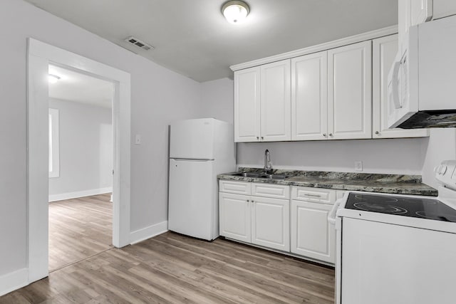 kitchen with white appliances, white cabinetry, light hardwood / wood-style flooring, and sink