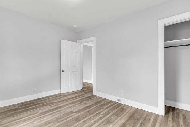 unfurnished bedroom featuring light wood-type flooring and a closet