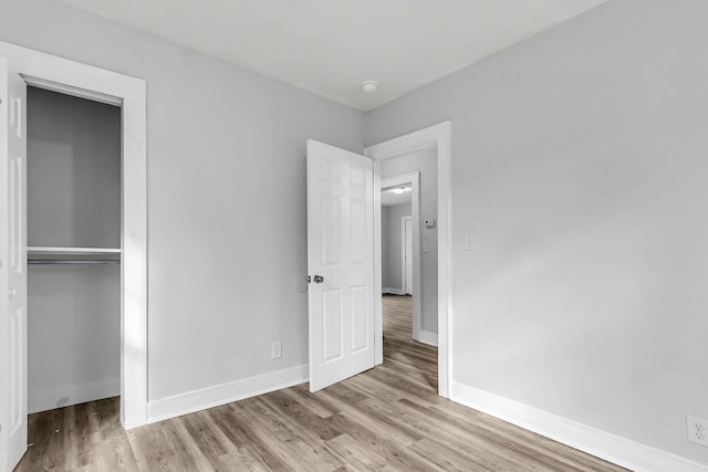 unfurnished bedroom featuring light hardwood / wood-style flooring and a closet