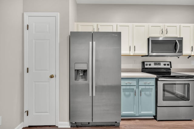 kitchen featuring appliances with stainless steel finishes, white cabinetry, and light hardwood / wood-style floors