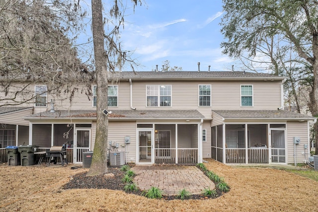 back of house featuring central air condition unit, a yard, a patio, and a sunroom