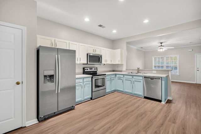 kitchen with ceiling fan, appliances with stainless steel finishes, crown molding, and white cabinetry