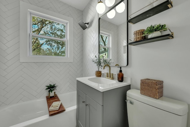 full bathroom featuring vanity, tiled shower / bath combo, and toilet