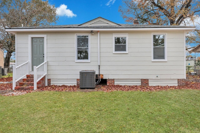 back of house with a lawn and central air condition unit