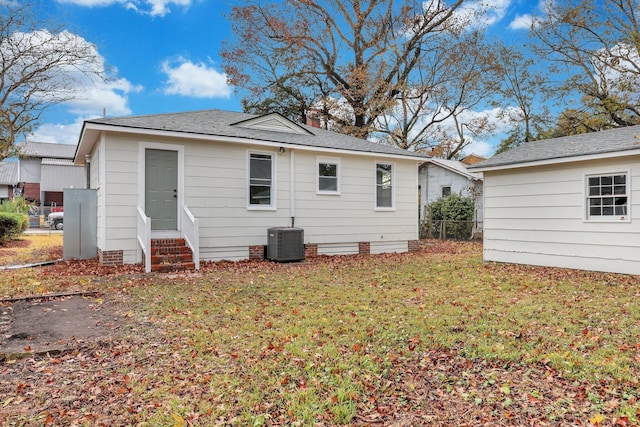 rear view of property with a yard and central air condition unit