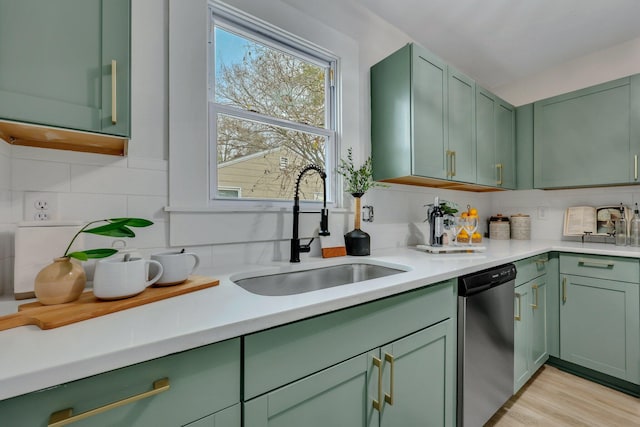 kitchen featuring stainless steel dishwasher, green cabinetry, and sink