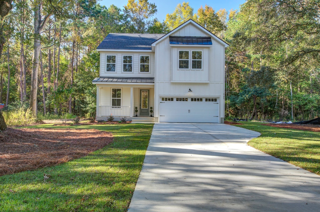 view of front of home with a porch, a garage, and a front lawn