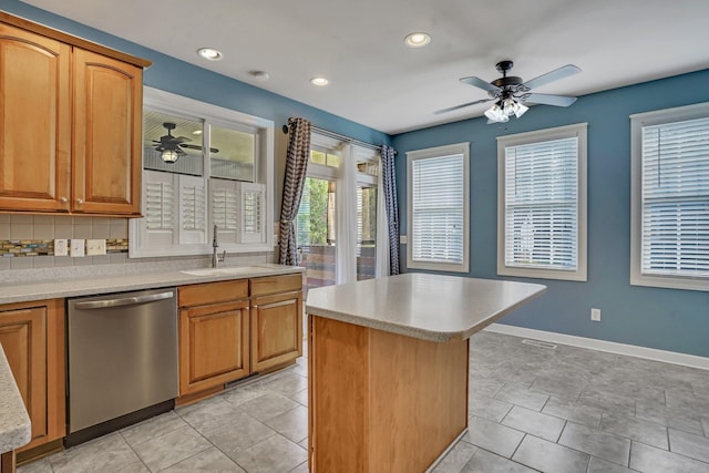 kitchen with light countertops, stainless steel dishwasher, brown cabinets, and a center island