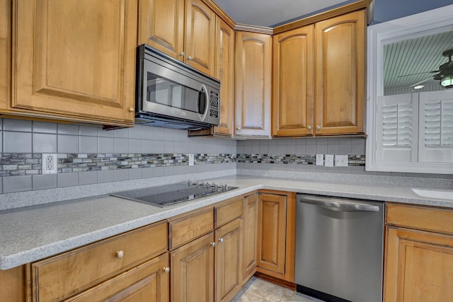 kitchen featuring brown cabinetry, ceiling fan, tasteful backsplash, and appliances with stainless steel finishes